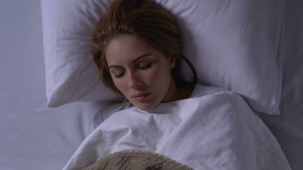 Одинокая женщина спит в постели, слезы на лице, негативные сны, кошмары — стоковое видео