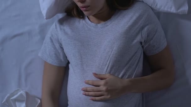 Pregnant woman holding tummy and turning in bed, uncomfortable sleeping — Stock Video