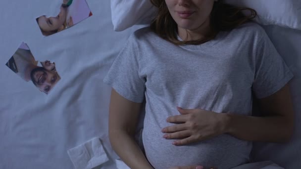 Femme enceinte pleurant au lit, photo de famille déchirée à proximité, trahison et divorce — Video