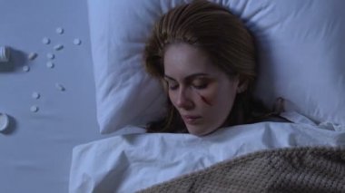 Dökülen hapların yanında yatan yaralı yüzü olan ölü kadın, yanıp sönen ışıklar yanıp sönüyor