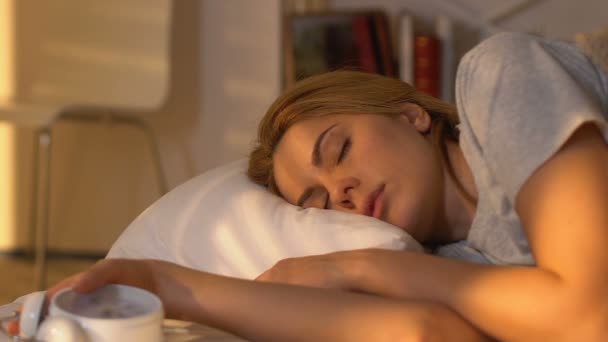 Жінка прокидається і дивиться на будильник, поспішає в ліжко, вранці — стокове відео