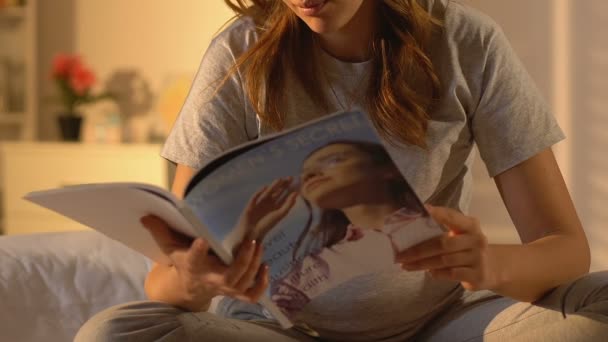 Mujer embarazada leyendo revista, consejos para la salud de las mujeres durante el trimestre, recién nacido — Vídeos de Stock