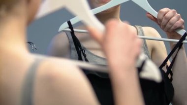 Depoda uygun bir elbise seçen genç bayan, parti ya da balo için hazırlanıyor.