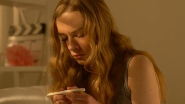 Hamilelik testi tutan titreyen elleri ile Genç kız, sonuç hakkında endişeli