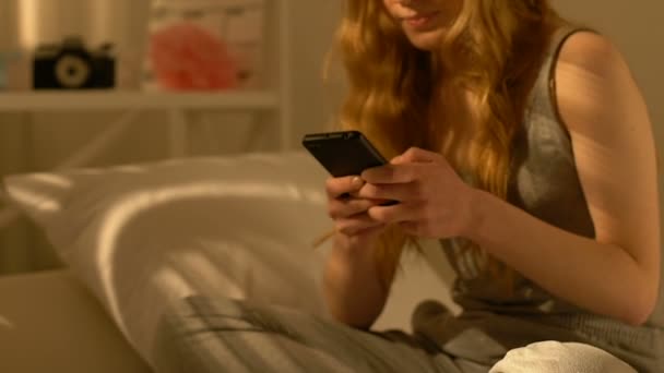 Feliz chica adolescente sosteniendo teléfono inteligente, charlando con el novio, primeras relaciones — Vídeo de stock