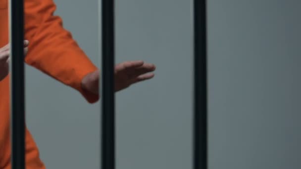 Черный заключенный с ножом нападает на сокамерника за решеткой — стоковое видео