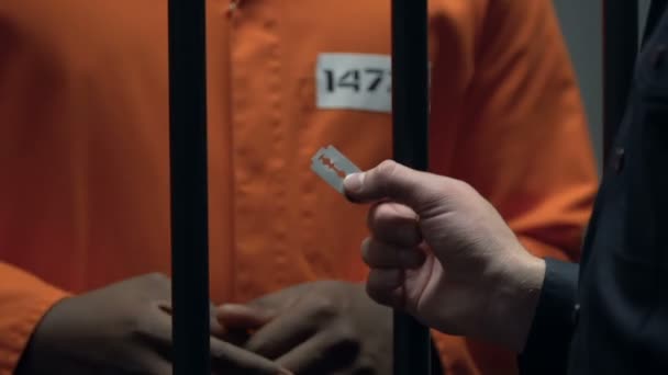 Oficer więzienny dając ostrze African-American więzień, pomagając uciec — Wideo stockowe