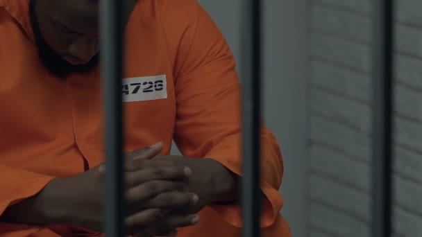Fängelse officer stående framför cell med afro-amerikanska farliga fånge — Stockvideo