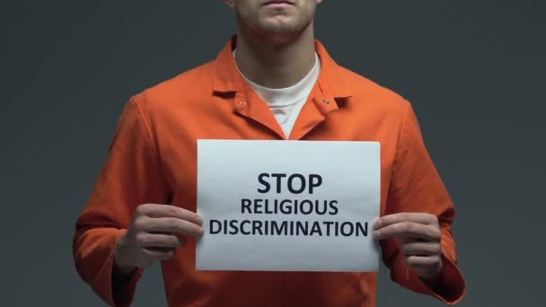 Detener la discriminación religiosa frase en la tarjeta en manos de prisionero caucásico — Vídeos de Stock