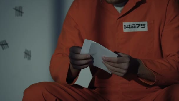 Caucasian prisoner reading letter from beloved, male criminal missing family — Stock Video