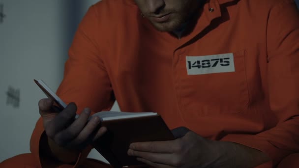 Prisionero caucásico leyendo libro en la celda, educación durante la cárcel, primer plano — Vídeo de stock