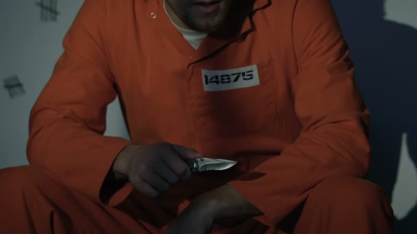 Prisioneiro caucasiano segurando faca, pensando em suicídio, transtornos mentais — Vídeo de Stock