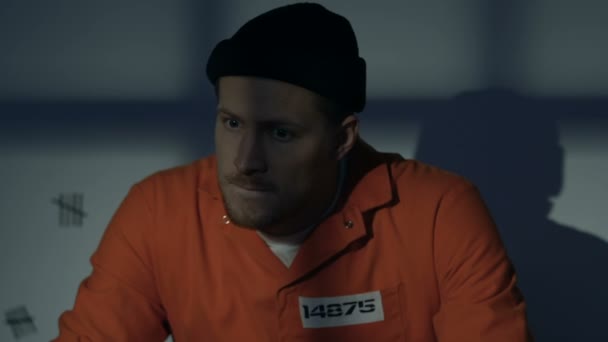 Beyaz erkek mahkûm hücrede bıçakla oturuyor, kaçmayı planlıyor, özgürlük — Stok video