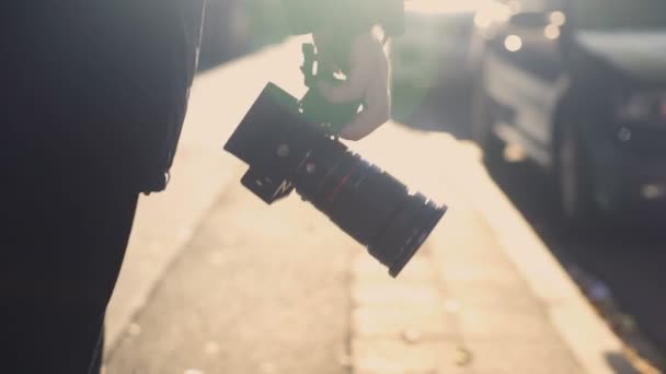 Профессиональный фотожурналист держит камеру, ходит по улице, папарацци шпионит — стоковое видео