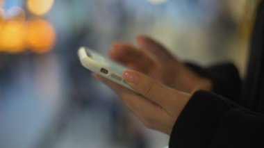 Akıllı telefonda yazan bayan, alışveriş merkezinde ayakta, ücretsiz wifi bağlantısı