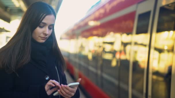 Dactylographie féminine au téléphone près du train, paiement mobile rapide pour les technologies de billets 