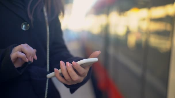 Femme vérifiant le point de destination au téléphone et entrant dans le train, application de billet en ligne — Video