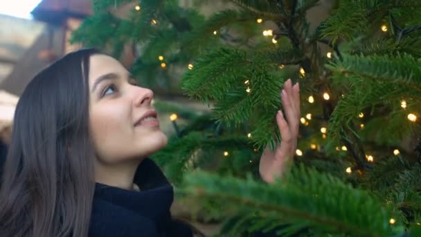 Весела приваблива дама дивиться на різдвяні прикраси, чекає на свята — стокове відео