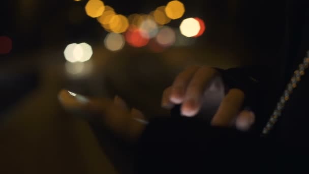 Feminino digitando no smartphone em pé na cidade noturna iluminada, nomeação — Vídeo de Stock