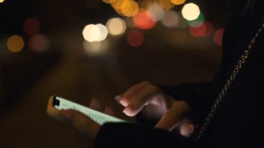 Bayan telefonda sohbet, ışıklı şehirde gece geç saatlerde yürüyüş, arkadaş kalma