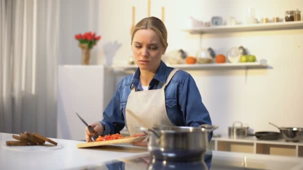 Jonge mooie vrouw ongelukkig met koken in de keuken, vervelen en moe van klusjes — Stockvideo