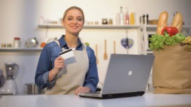 Kız mutfakta banka kartı tutan, internet üzerinden gıda satın memnun