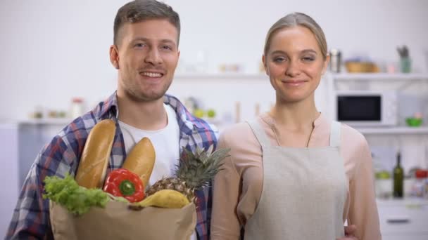 Ευτυχισμένο ζευγάρι κρατώντας τρόφιμα και τραπεζική κάρτα, έννοια της γρήγορης online παράδοσης — Αρχείο Βίντεο