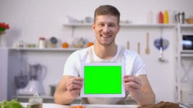 Yeşil ekran, yemek blogları ve uygulamalar şablonu ile tablet tutan neşeli adam
