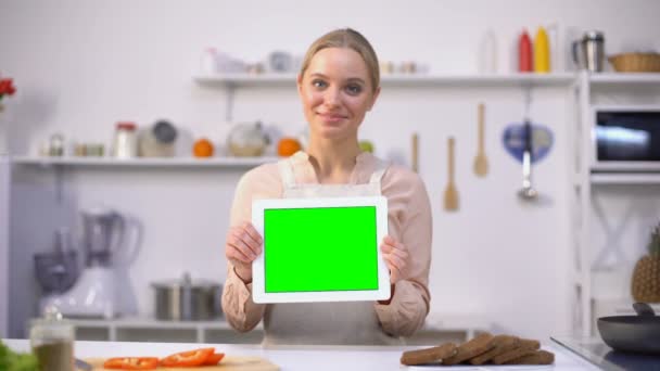 Веселая женщина держит планшет с зеленым экраном, кулинарные блоги и шаблоны приложений — стоковое видео