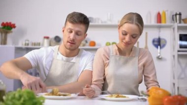 Genç çift makarna yeme, kamera, hızlı ve kolay yemek kavramı gülümseyerek
