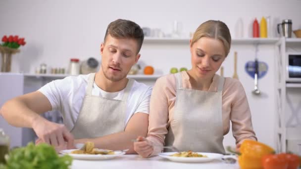 Молодая пара ест макароны, улыбаясь в камеру, концепция быстрого и легкого питания — стоковое видео