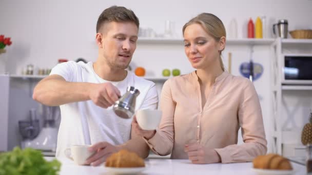 Bello uomo versa caffè preparato per ragazza carina e ottiene bacio, mattina romantica — Video Stock