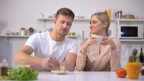 Beau mec se moquant de sa copine, faisant semblant de se nourrir de gâteau, de romance — Video