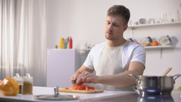 Pohledný mládenec připravuje rajskou omáčkou, baví se vaření, hobby — Stock video