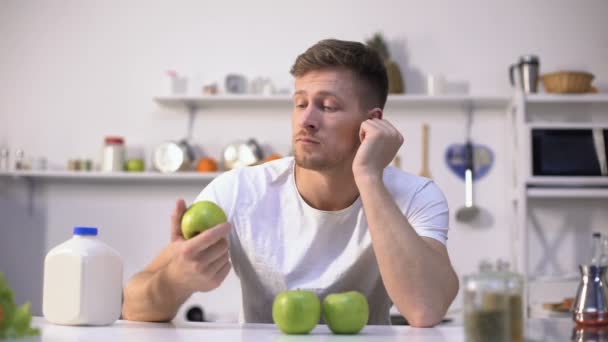 Молодой парень жонглирует зелеными яблоками, начинает диету и здоровый образ жизни, витамины — стоковое видео