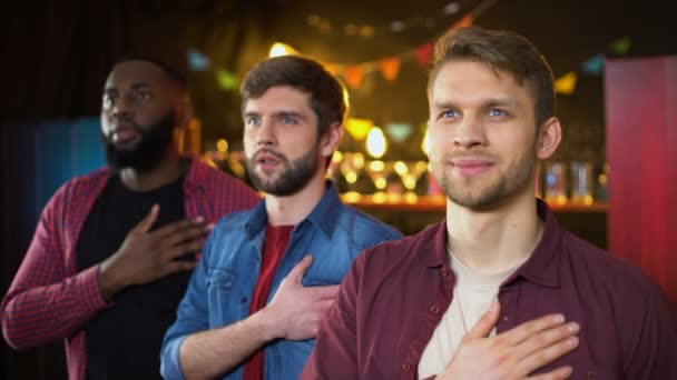 Patriottische voetbalfans luisteren naar Anthem en knuffelen, kijken naar spel in Bar — Stockvideo