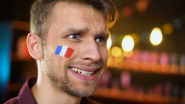 Yanaküzerinde Fransız bayrağı ile üzgün sakallı futbol taraftarı facepalm takım kaybetme yapma