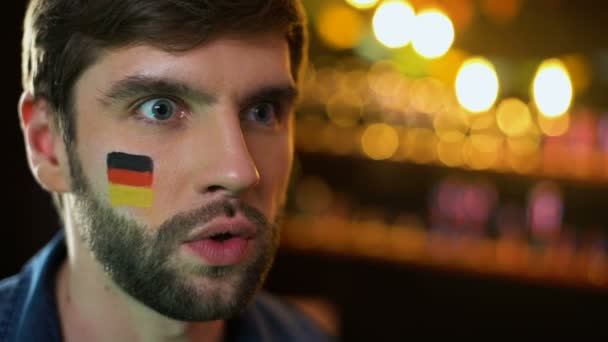 Joyful german fan with flag on cheek shouting and celebrating victory, goal — Stock Video