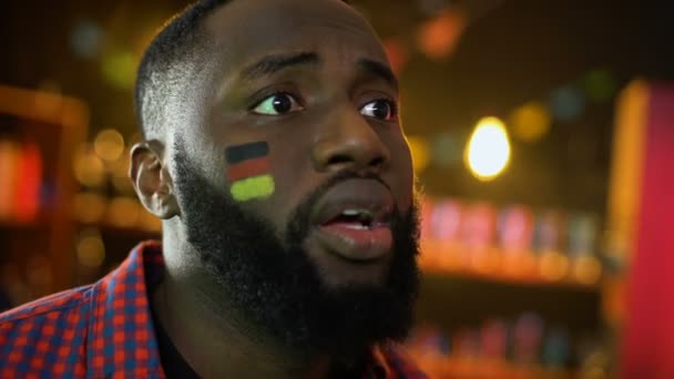 Разочарованный болельщик немецкого футбола с флагом на щеке, делающим лицо, команда проигрывает — стоковое видео