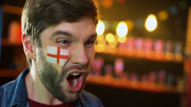 Веселый английский футбольный болельщик с флагом на груди делает жест "да", команда выигрывает — стоковое видео