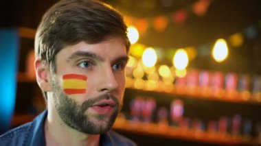 İspanyol futbol taraftarı yanağında bayrakla turnuvayı kazanan takım için tezahürat yapıyor
