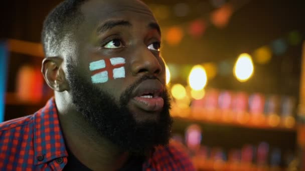 Black male with english flag painted on cheek disappointed football team failure — Stock Video