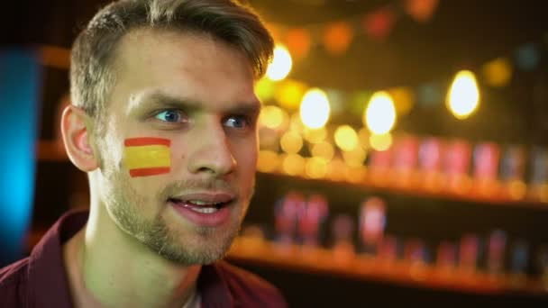 Беспокойный кавказский болельщик с испанским флагом на щеке недовольный результатом матча — стоковое видео