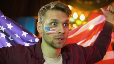 Son derece mutlu Amerikan futbol taraftarı ulusal bayrak sallayarak, gol kutluyor, kazanmak