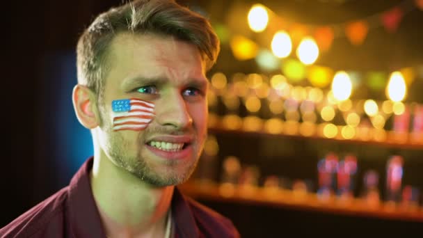 Nerveuze American Soccer fan met vlag op Wang ongelukkig met spel resultaat — Stockvideo