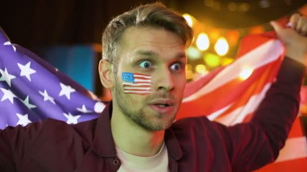 Extremadamente feliz fanático del fútbol americano ondeando bandera nacional, celebrando gol, ganar — Vídeos de Stock