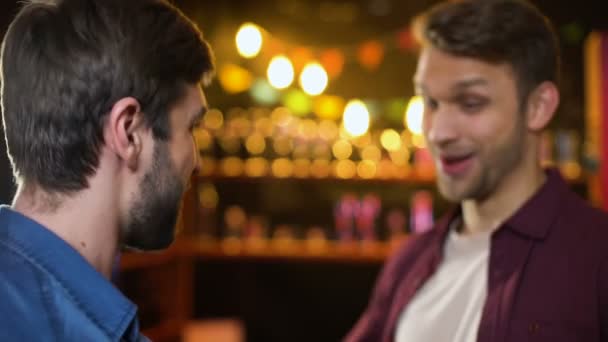 Веселые друзья встречаются в баре улыбаясь, делая приветственный жест, удовольствие — стоковое видео