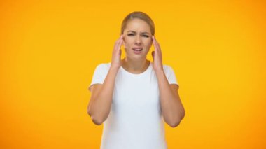 Young lady suffering headache on bright background, temple spasm, health care