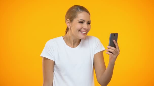 Весела молода жінка тримає доларові купюри, використовуючи додаток для смартфона, банківська справа — стокове відео