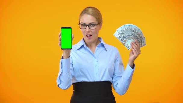 Mooie Kaukasische dame tonen groen scherm smartphone en dollars, Cashback — Stockvideo